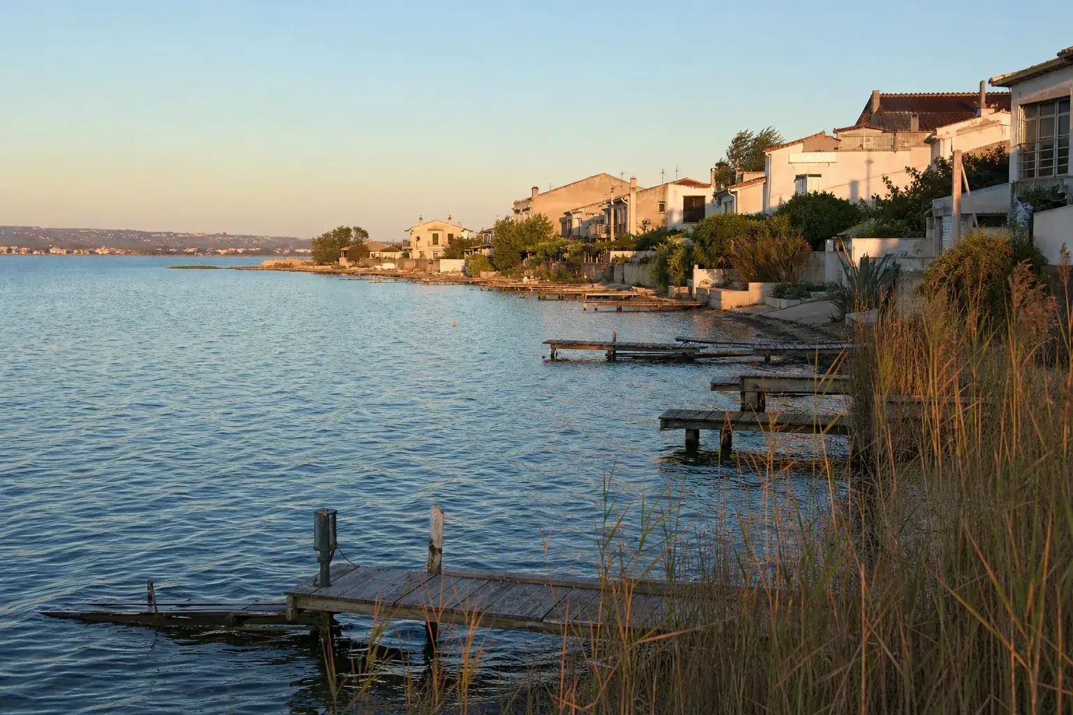 Bord de l’étang de Berre avec résidences claires en front d’eau, pontons et roseaux
