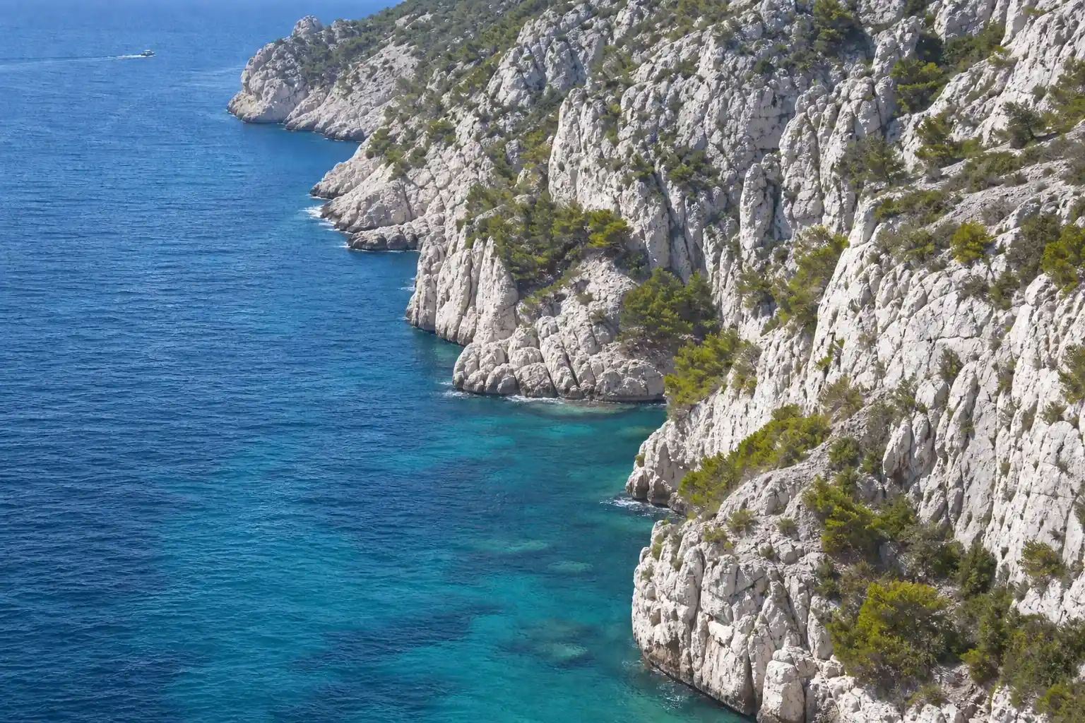Falaises calcaires des calanques marseillaises plongeant dans une eau turquoise