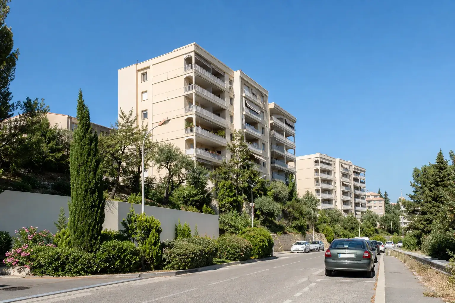Rue résidentielle des quartiers Sud de Marseille, immeubles clairs avec balcons et vue dégagée